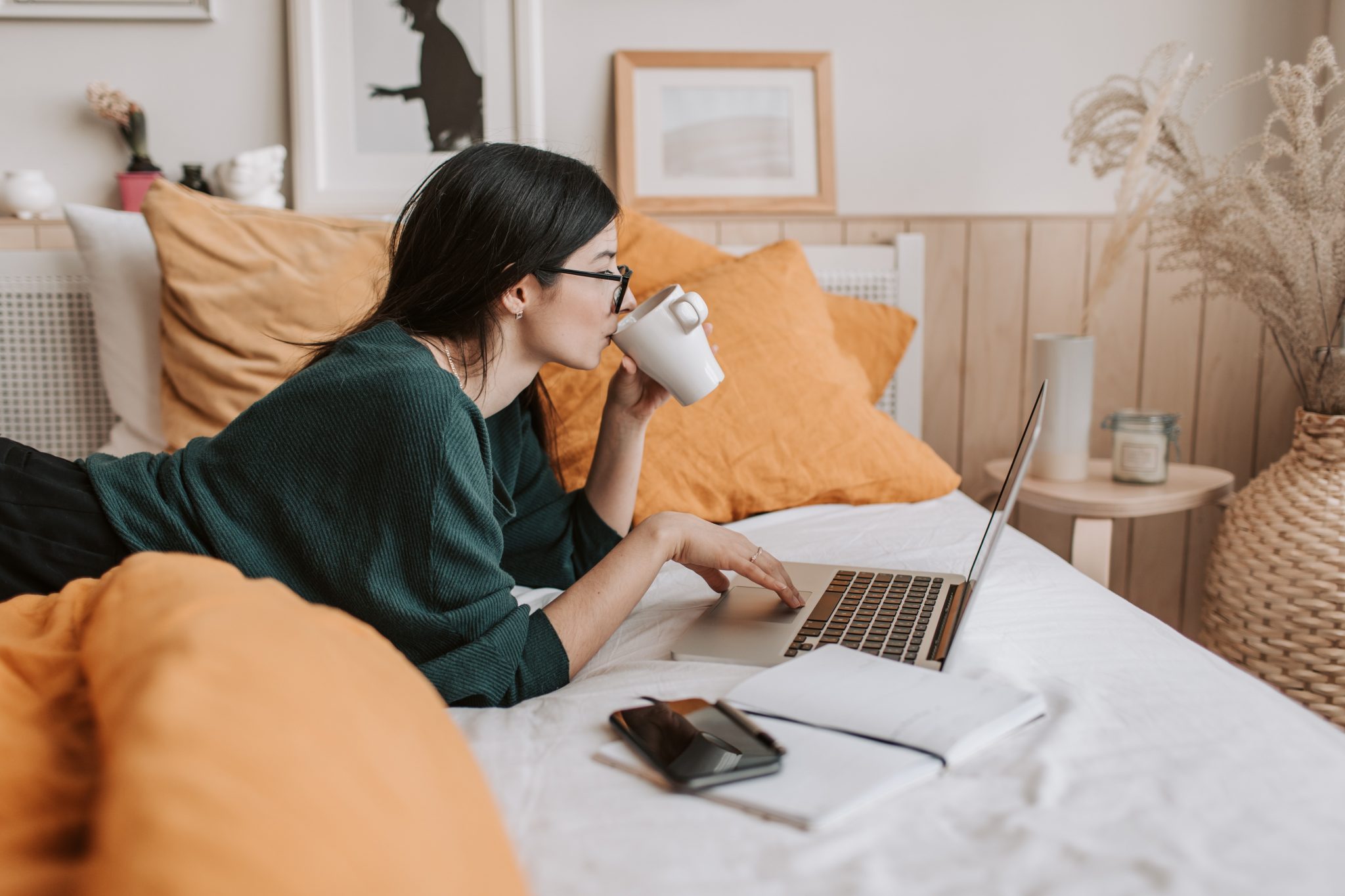 Woman sipping coffee while using a laptop