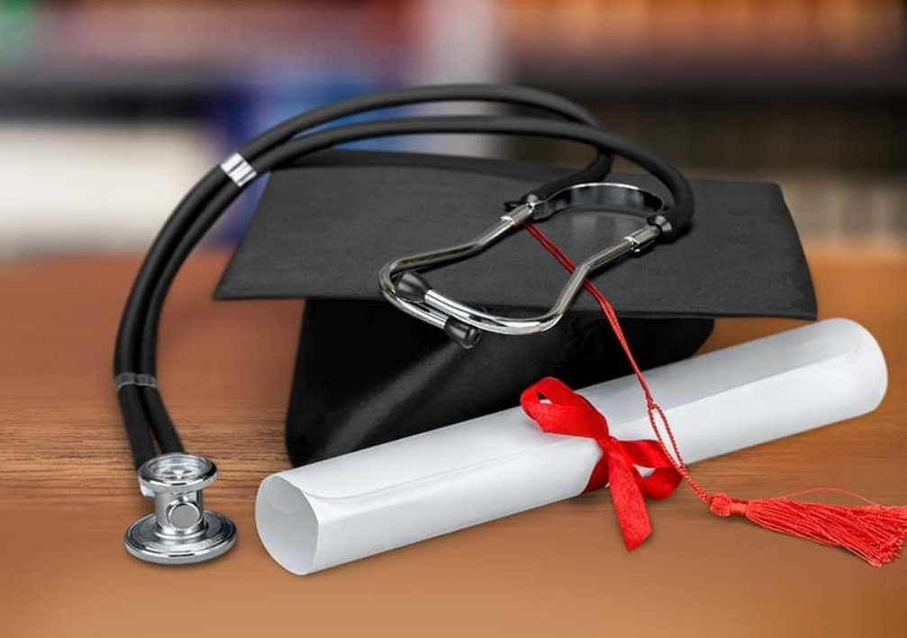 Graduation cap with diploma and stethoscope