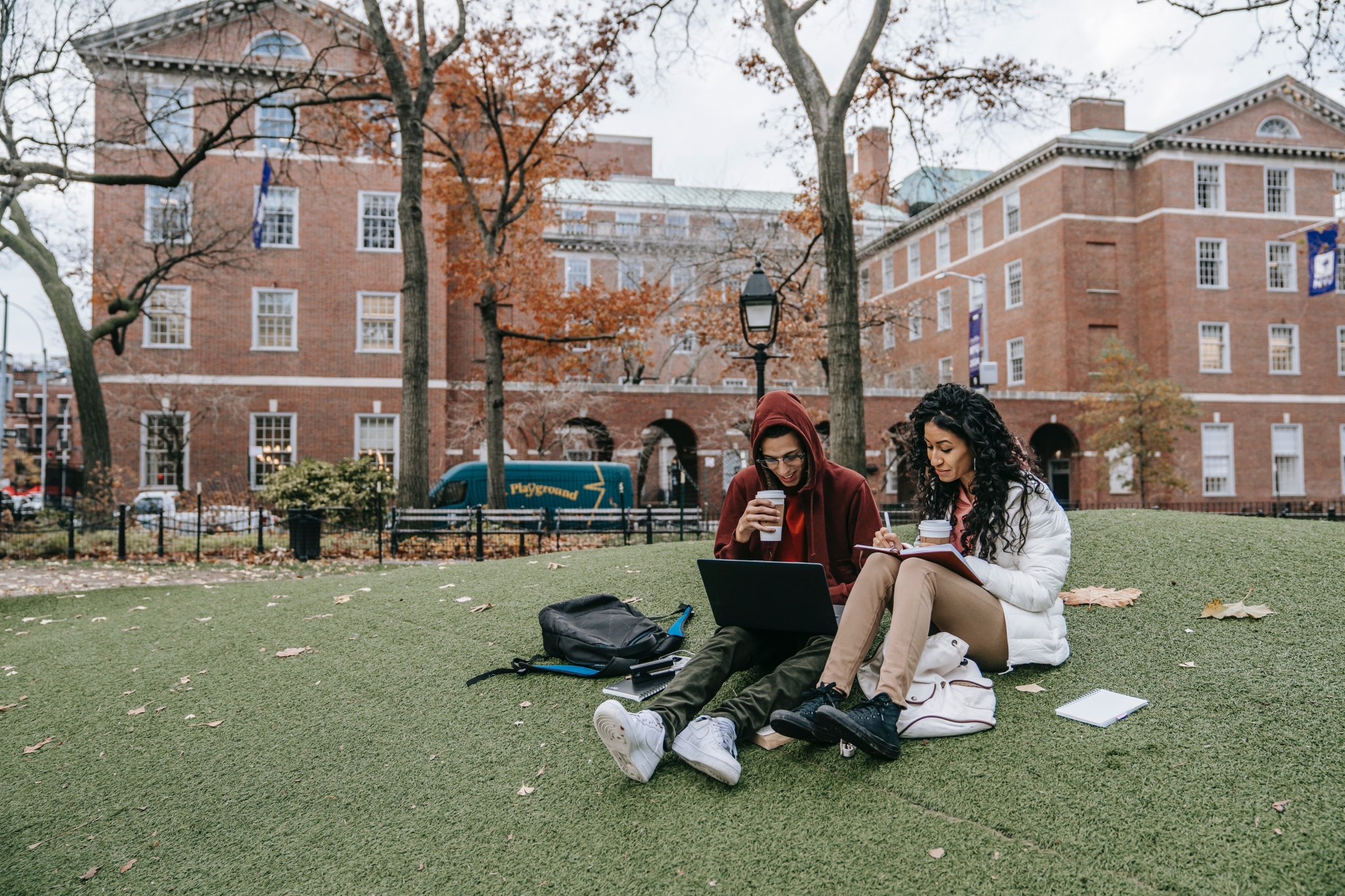 Two students sitting on the grass