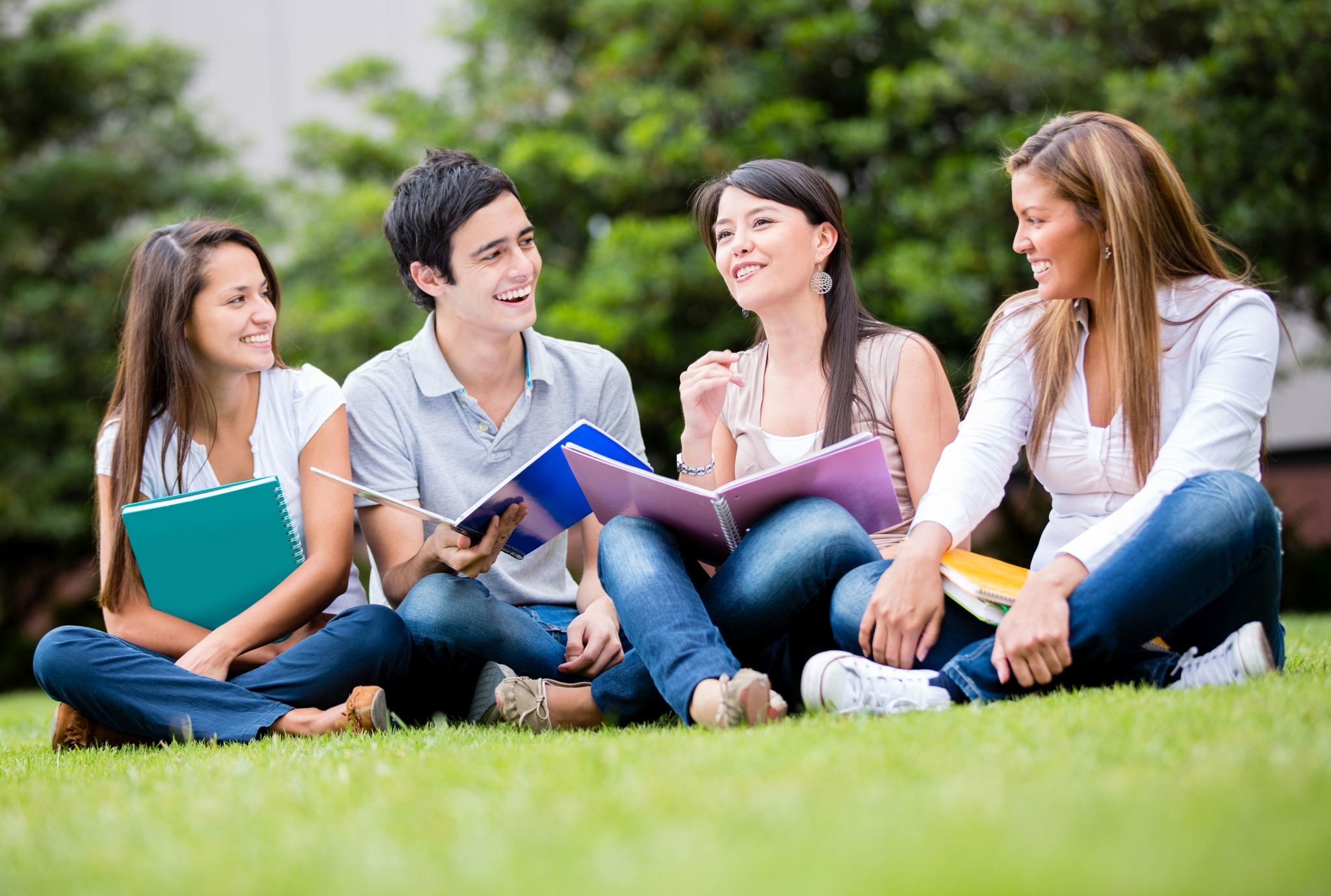 Happy group of students sitting in the grass