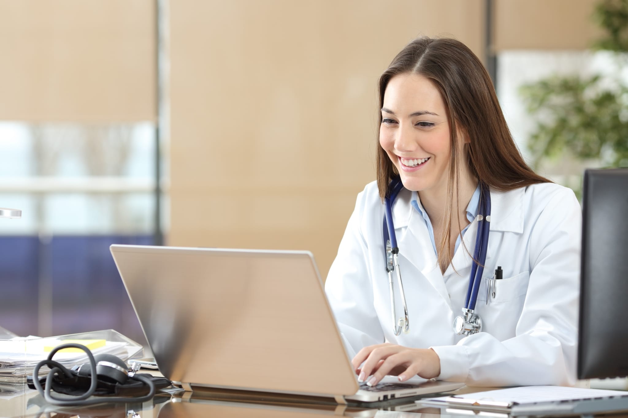 Smiling medical professional using a laptop