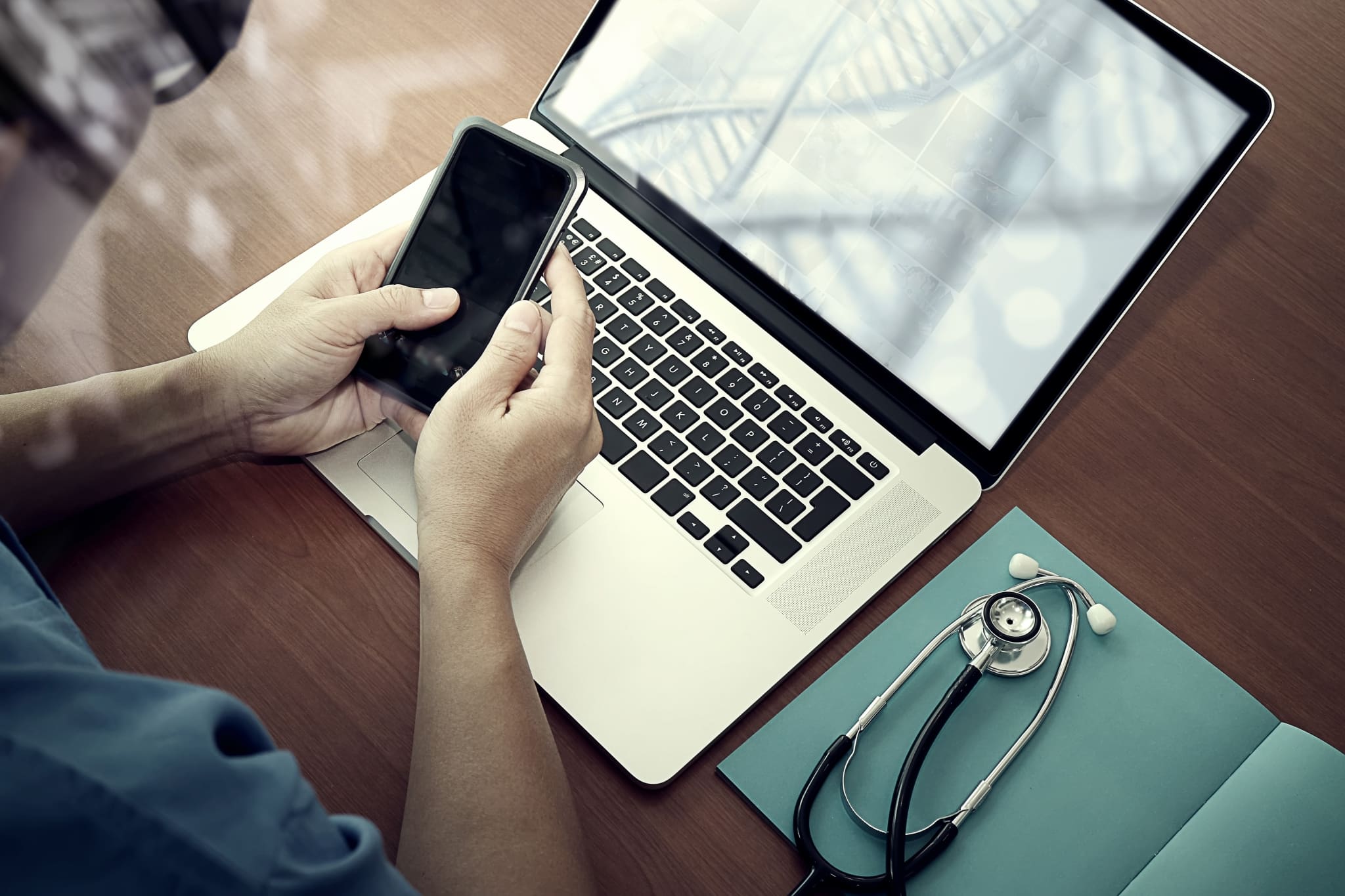 Aerial view of a nurse using a phone and laptop