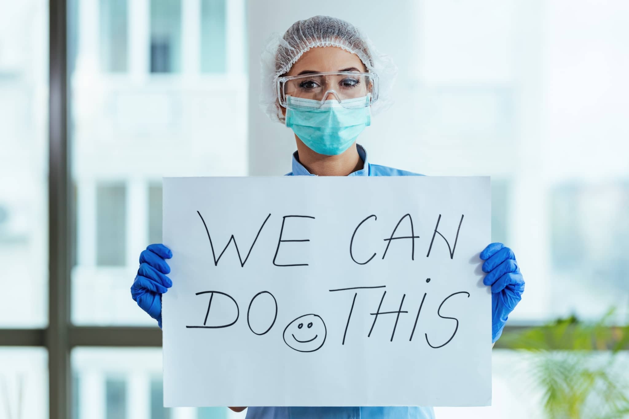 Healthcare worker holding a motivational sign