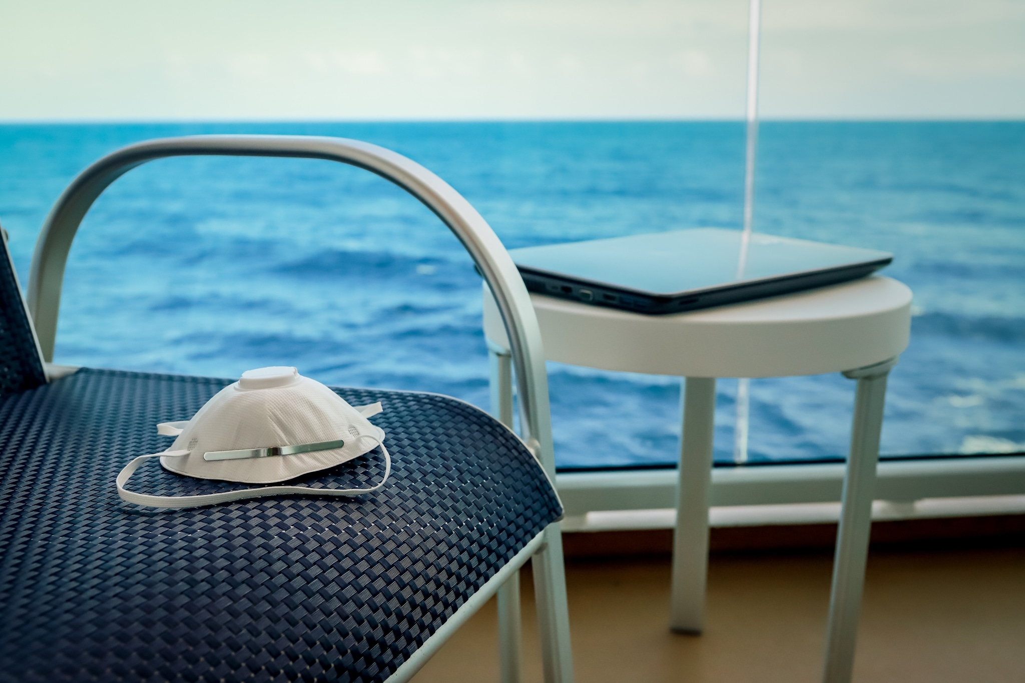 N95 mask on a chair with a view of the ocean