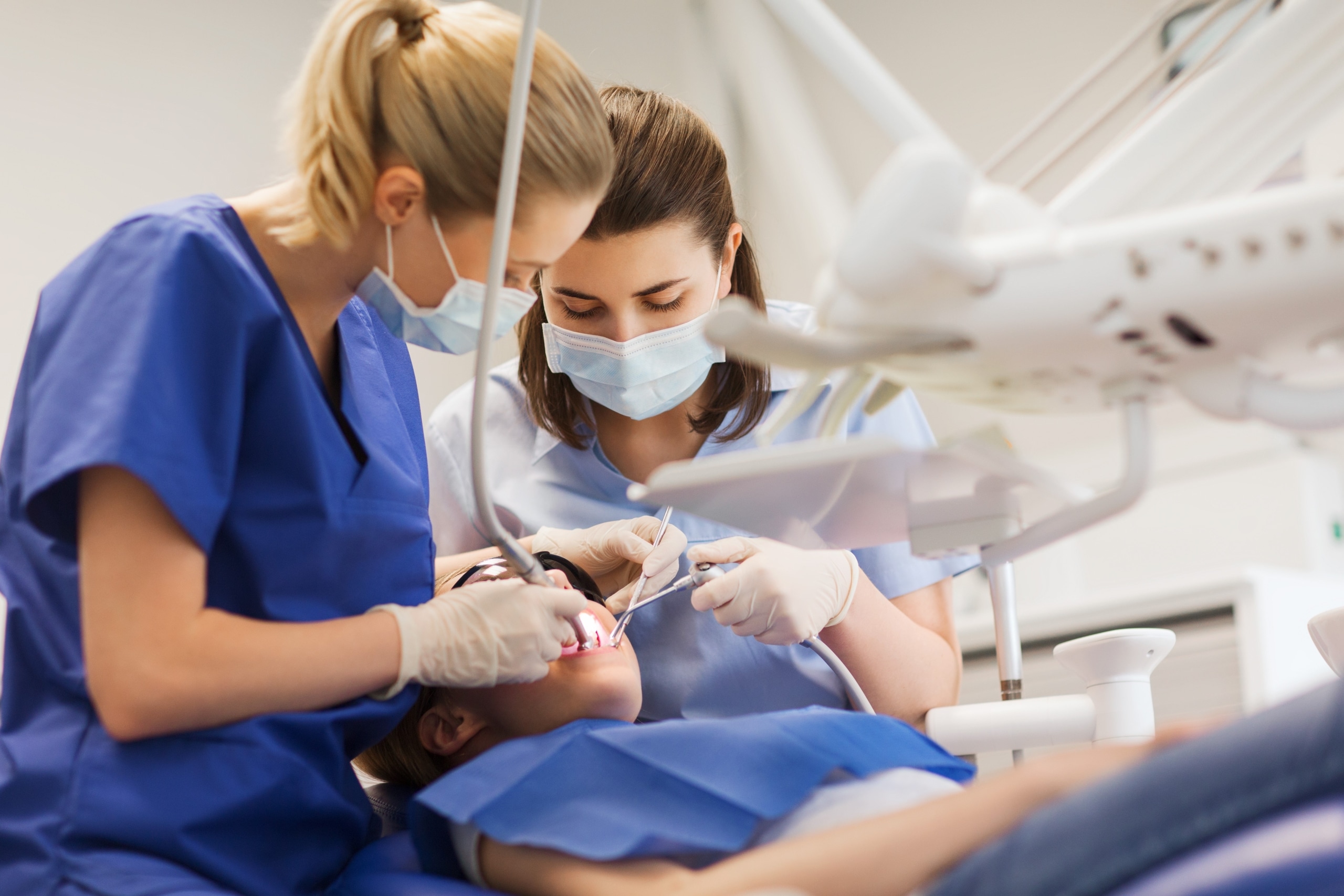 Dental professionals examining a patient's teeth