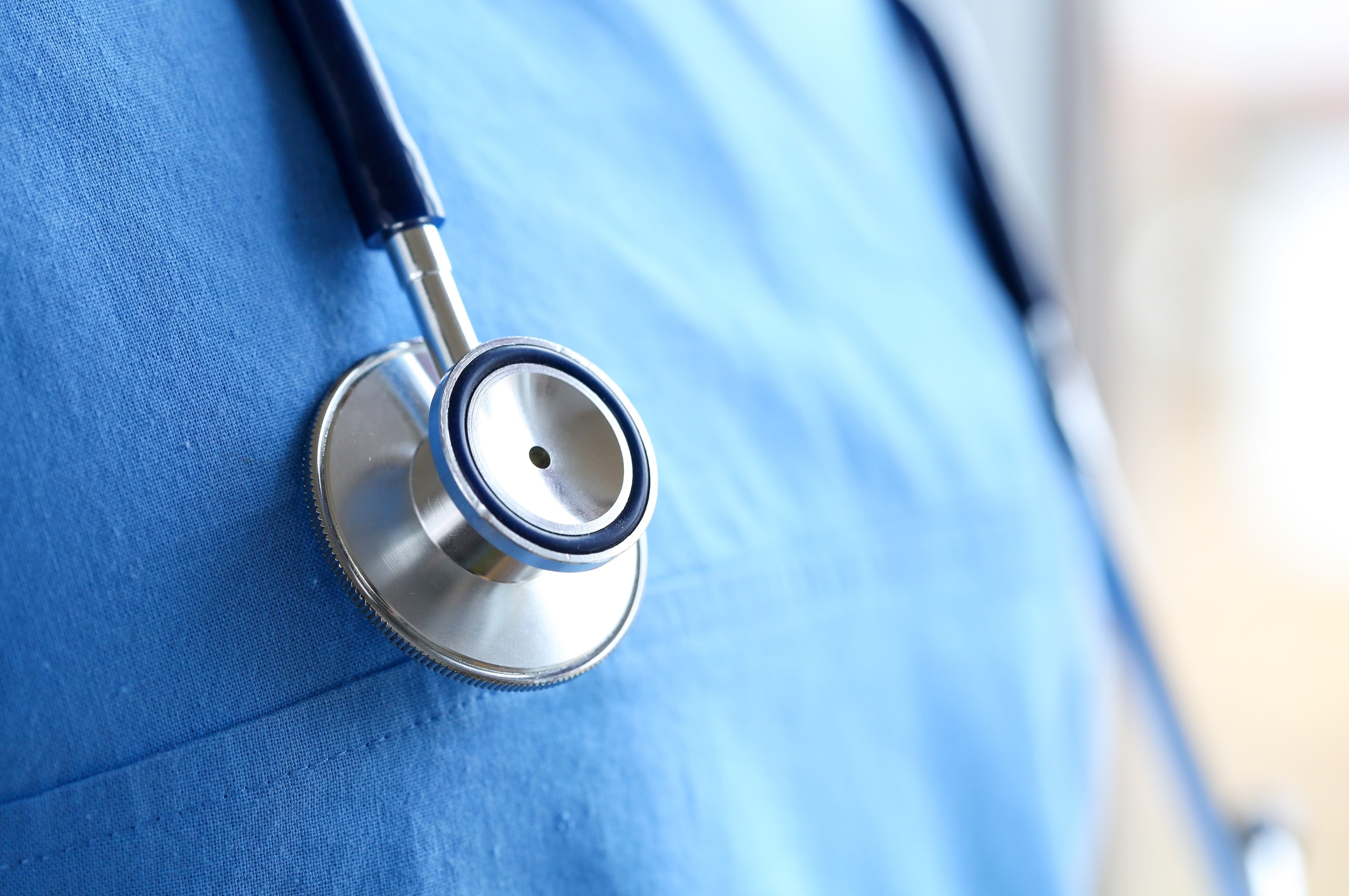 Close up of a medical professional wearing scrubs and a stethoscope