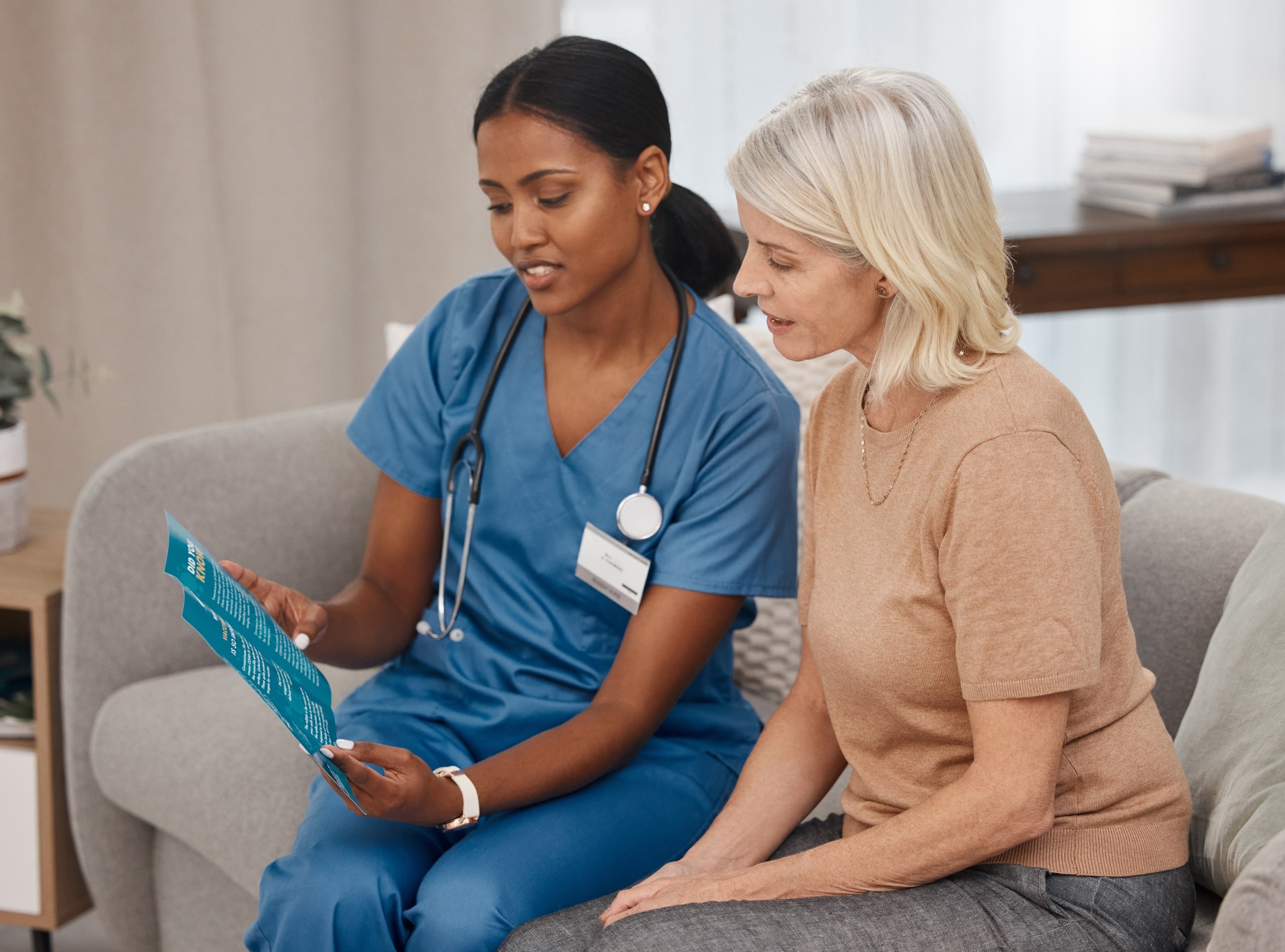 African-American nurse sitting with an elderly woman