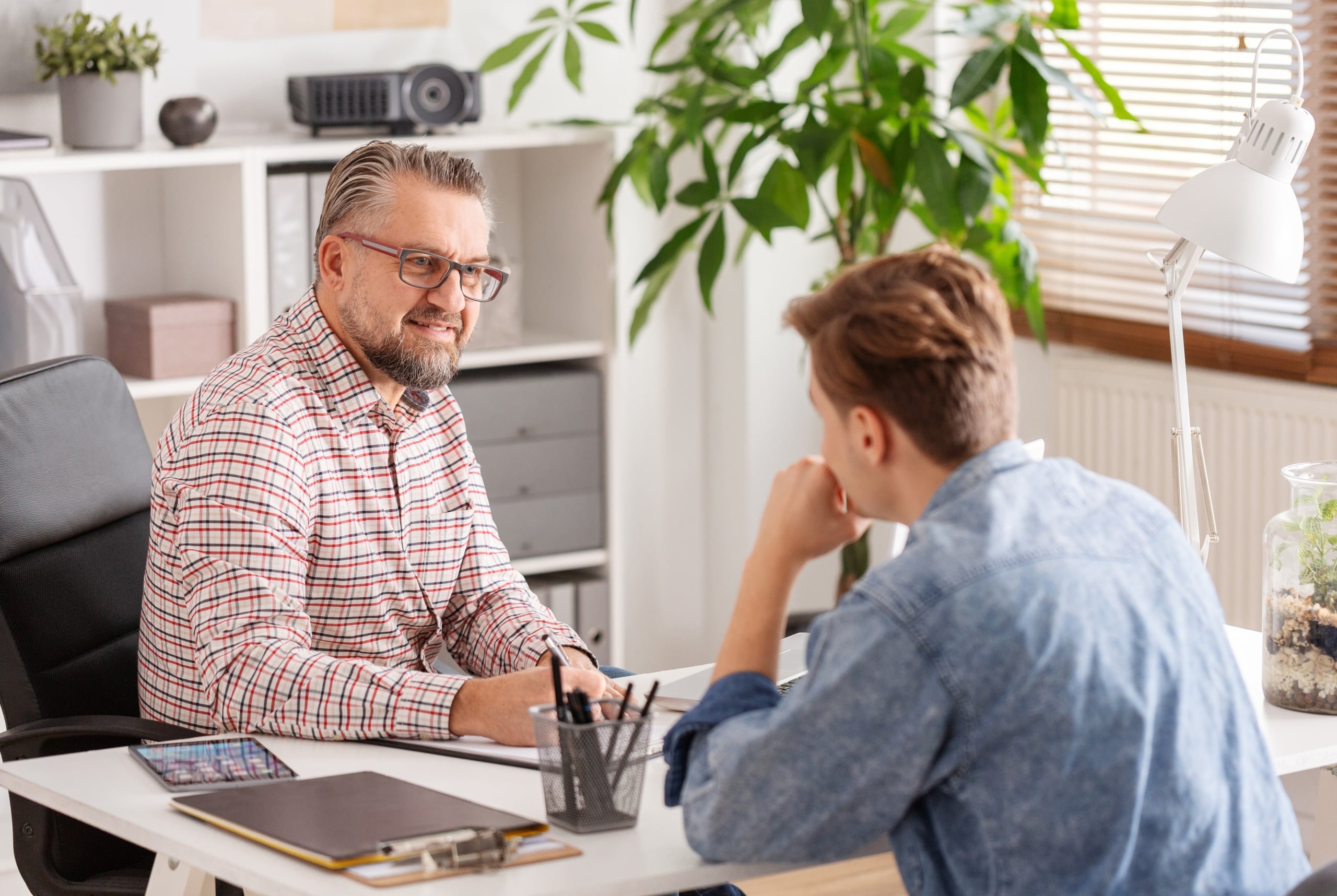 Two men sitting on opposite sides of a desk