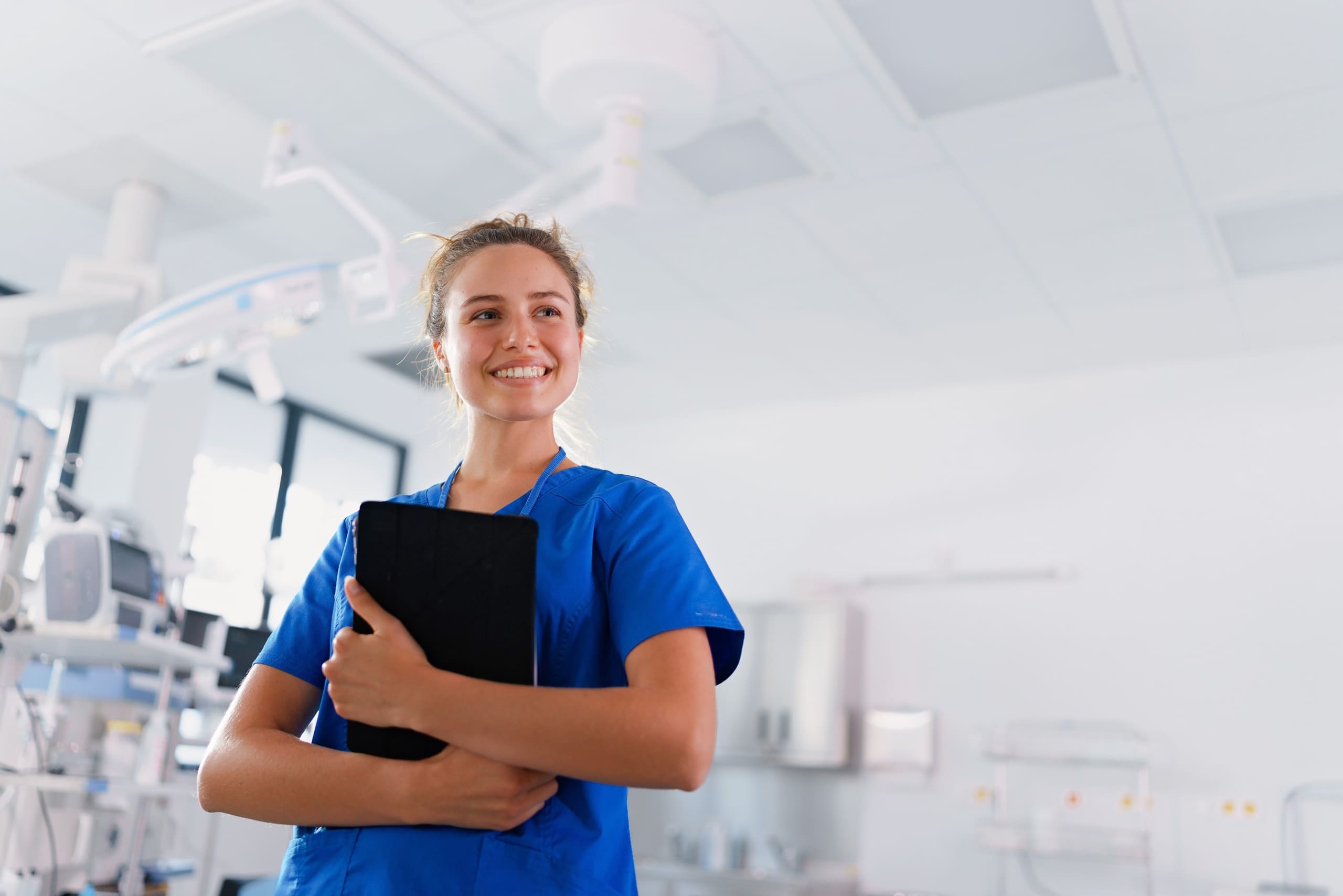 Nurse in scrubs holding a clipboard