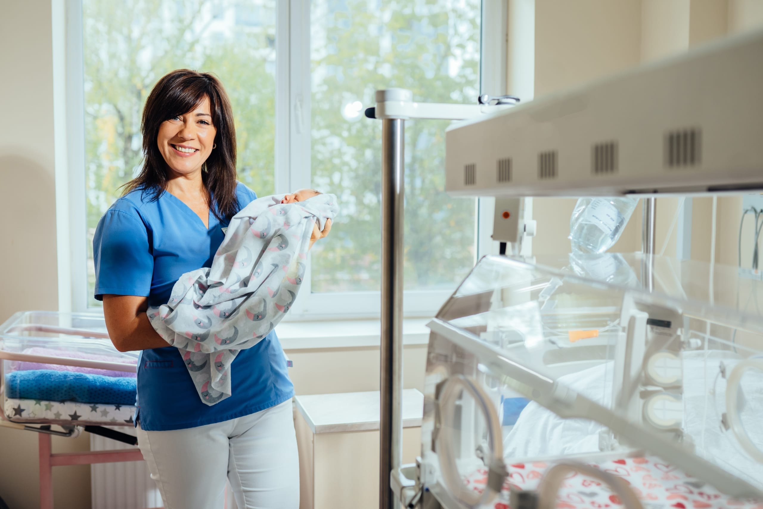Neonatal nurse holding a newborn baby
