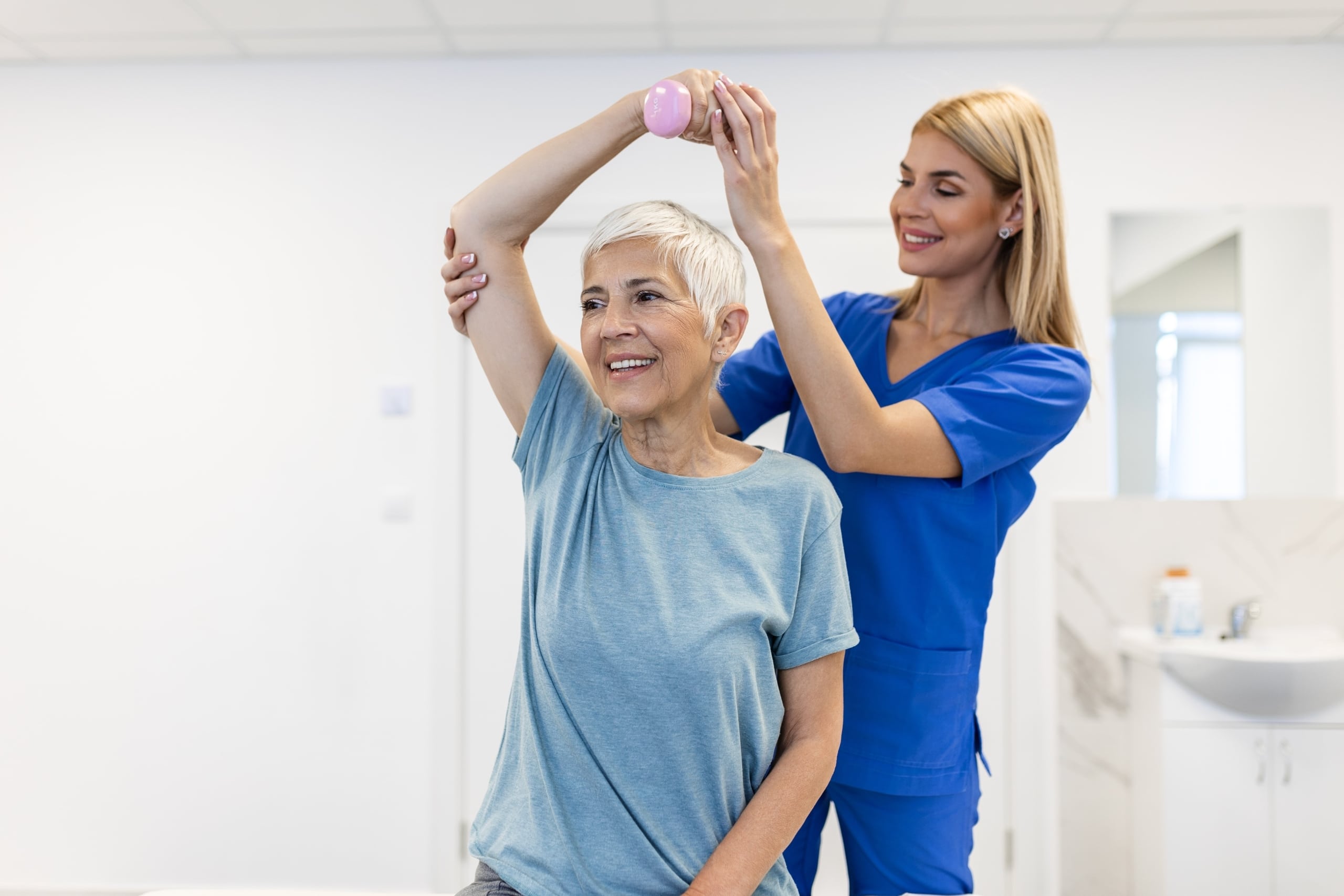 Older woman lifting weights in physical therapy