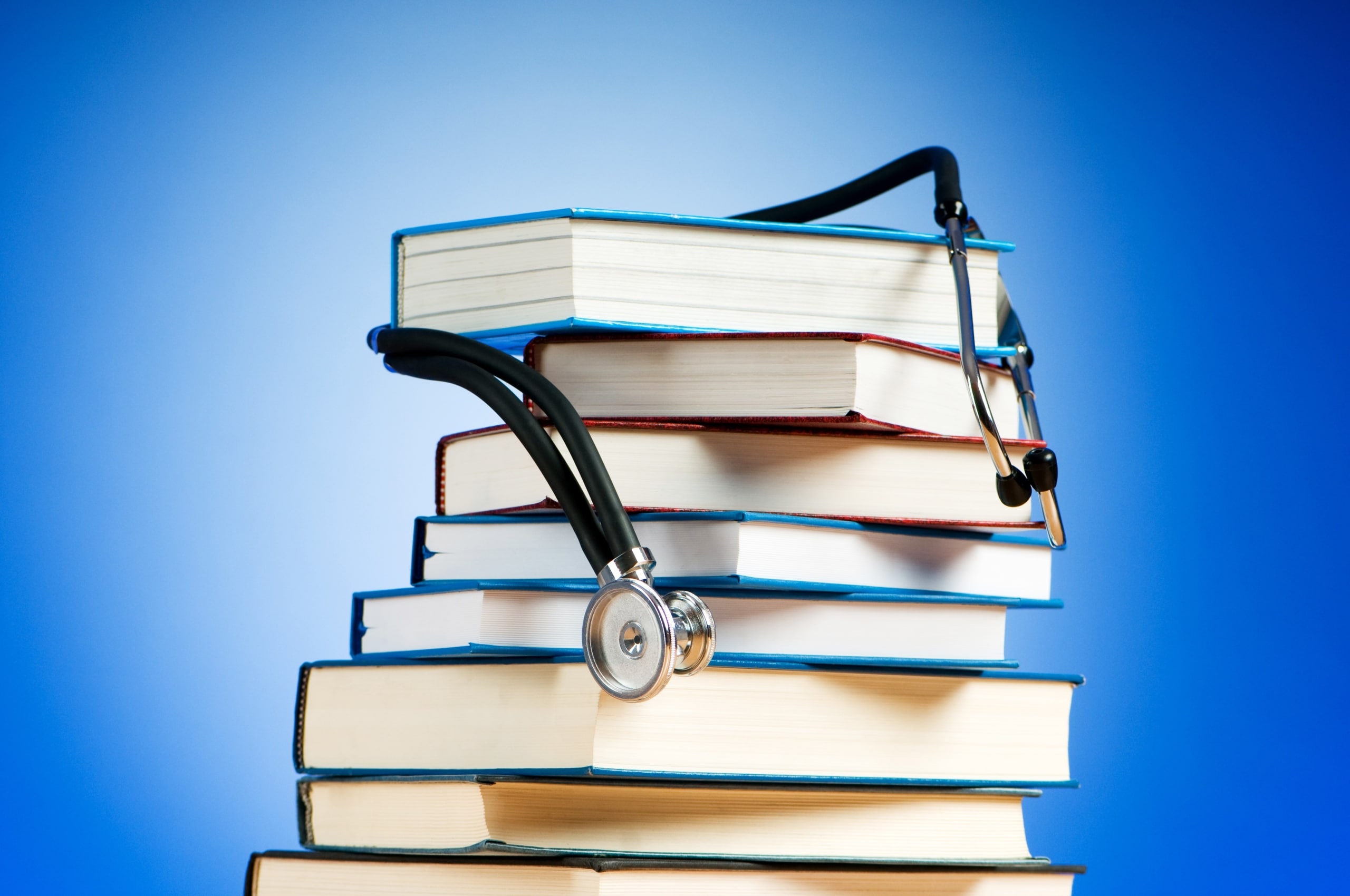 Stethoscope draped over a stack of textbooks