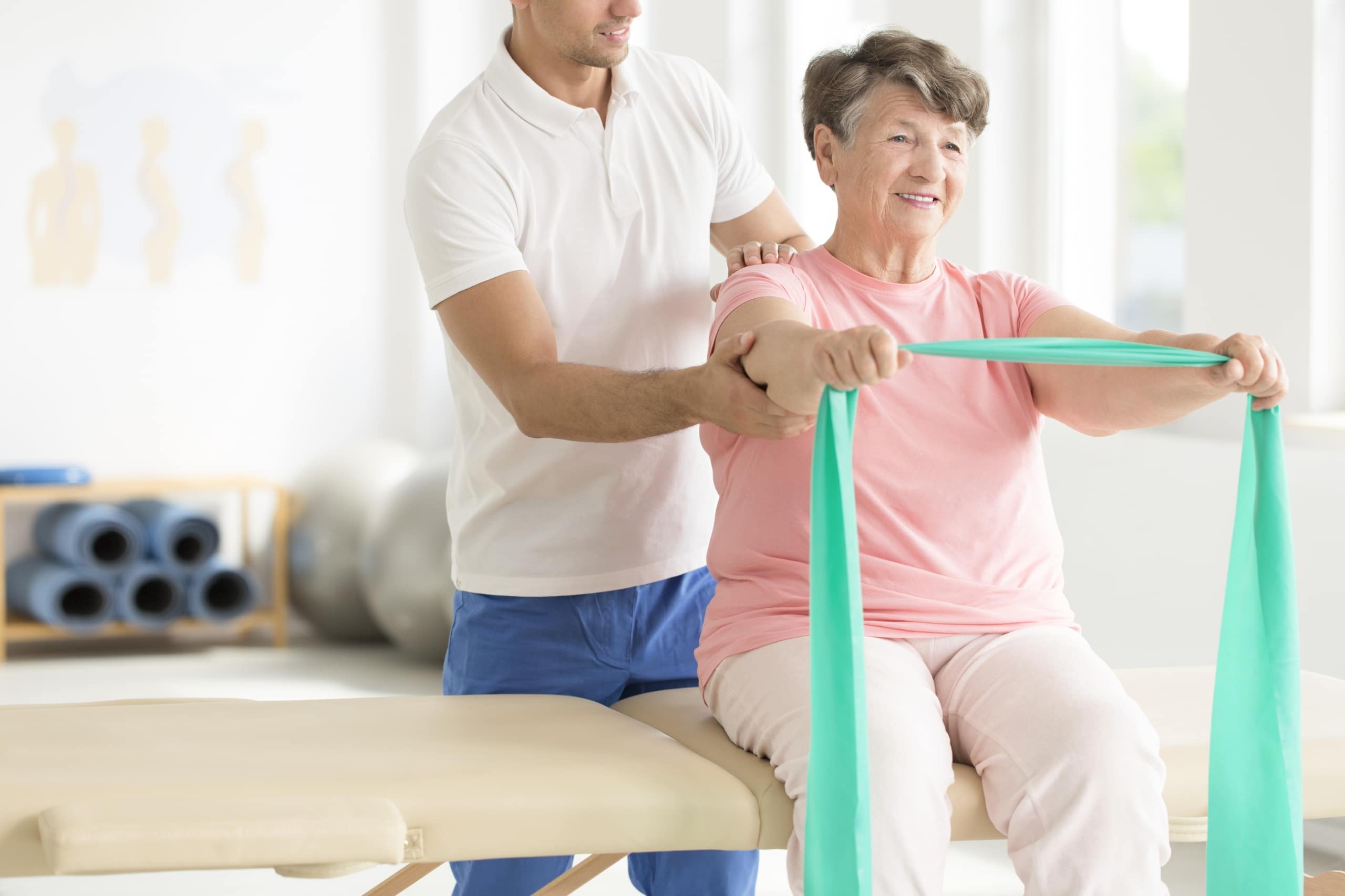 Elderly woman using an exercise band in physical therapy