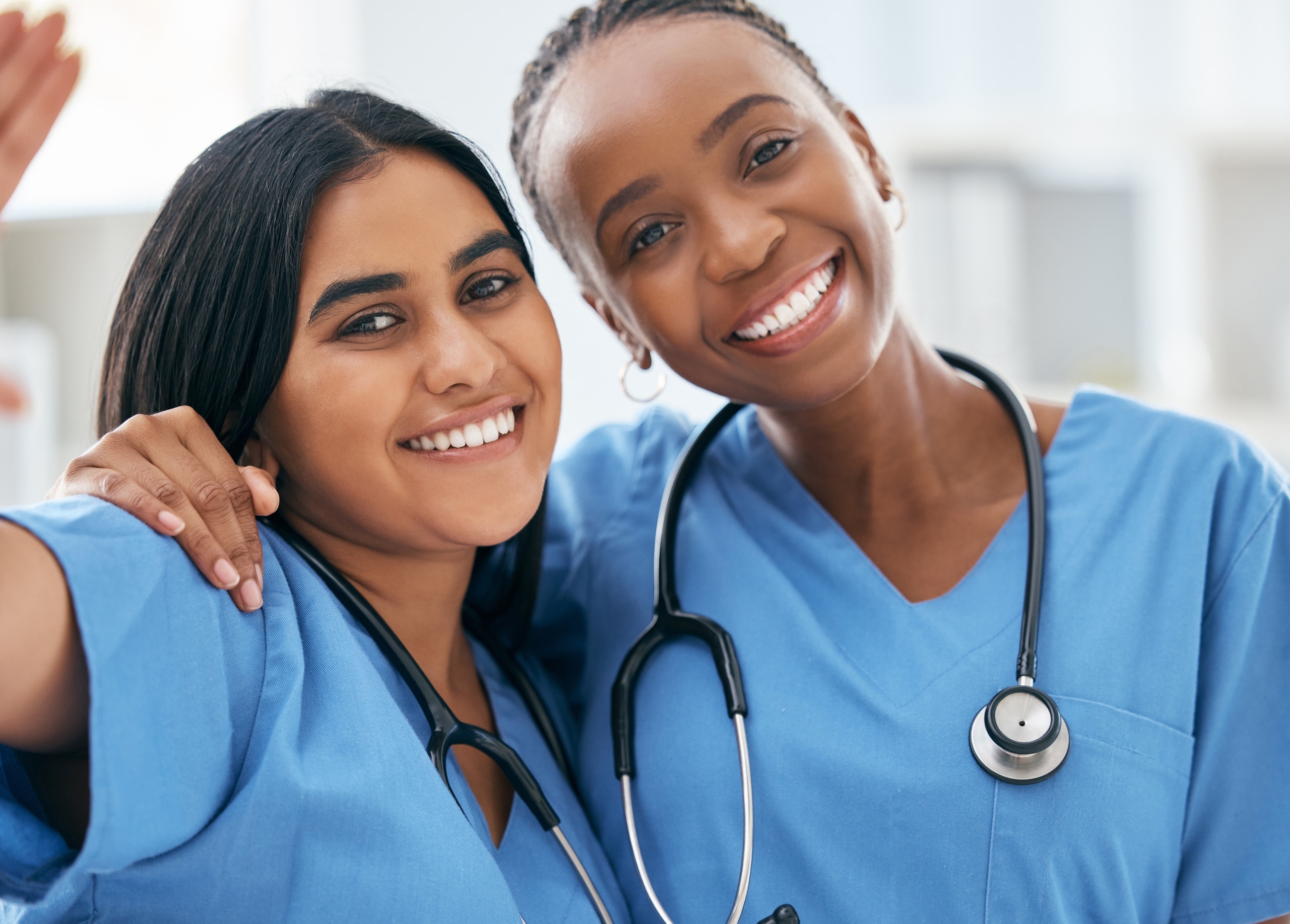 Two diverse medical professionals smiling together