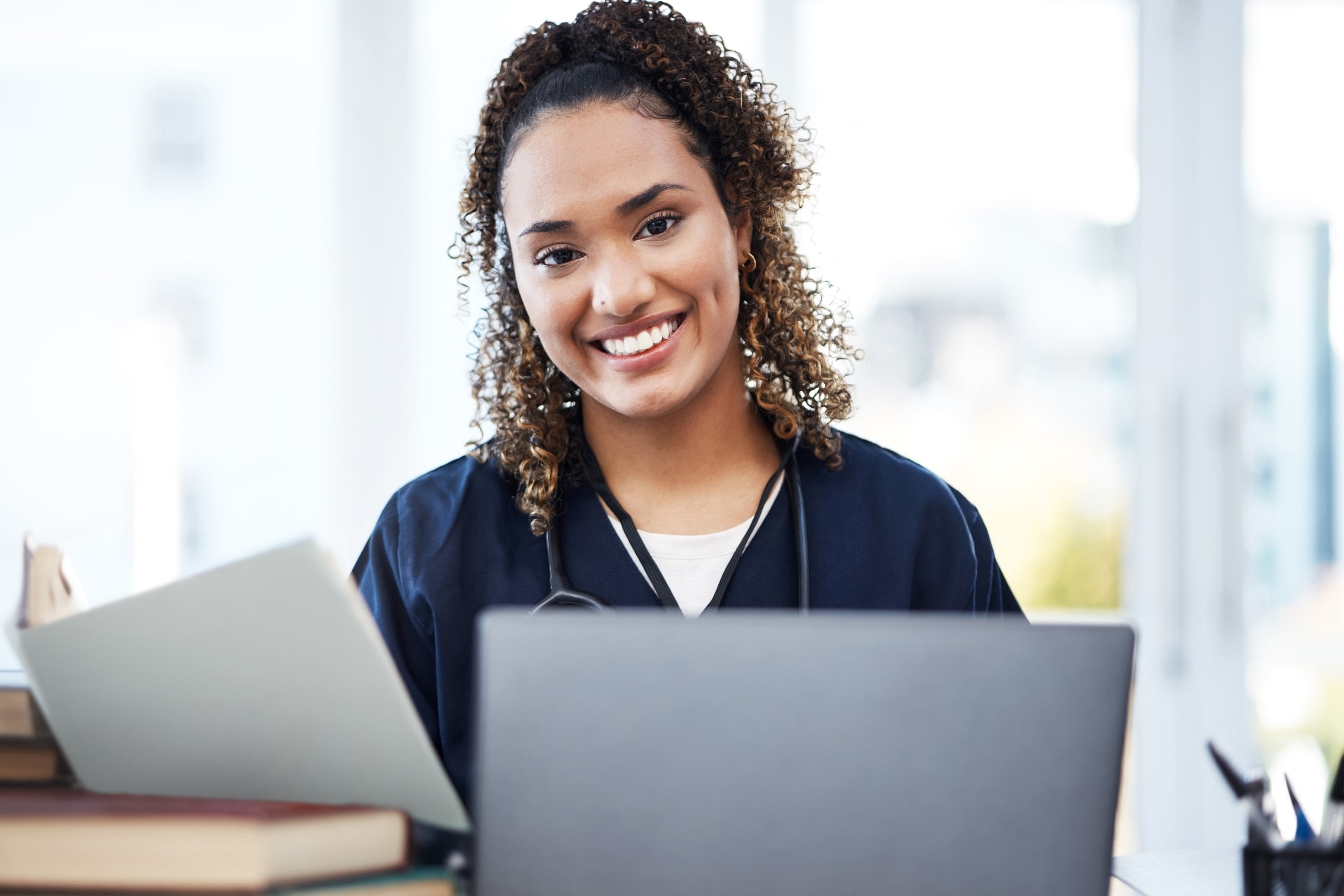 Smiling African-American nurse using a laptop