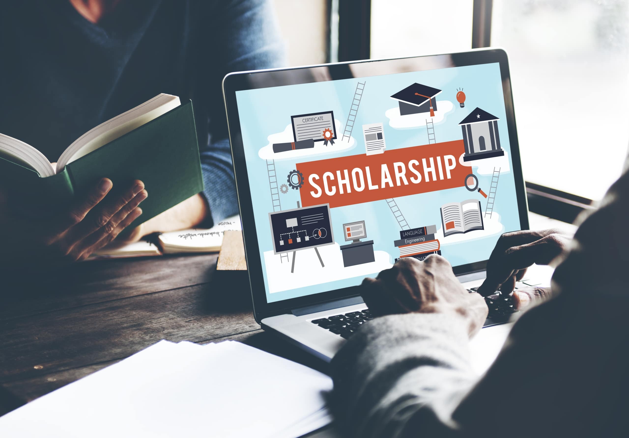 Man looking at a laptop screen that says scholarships