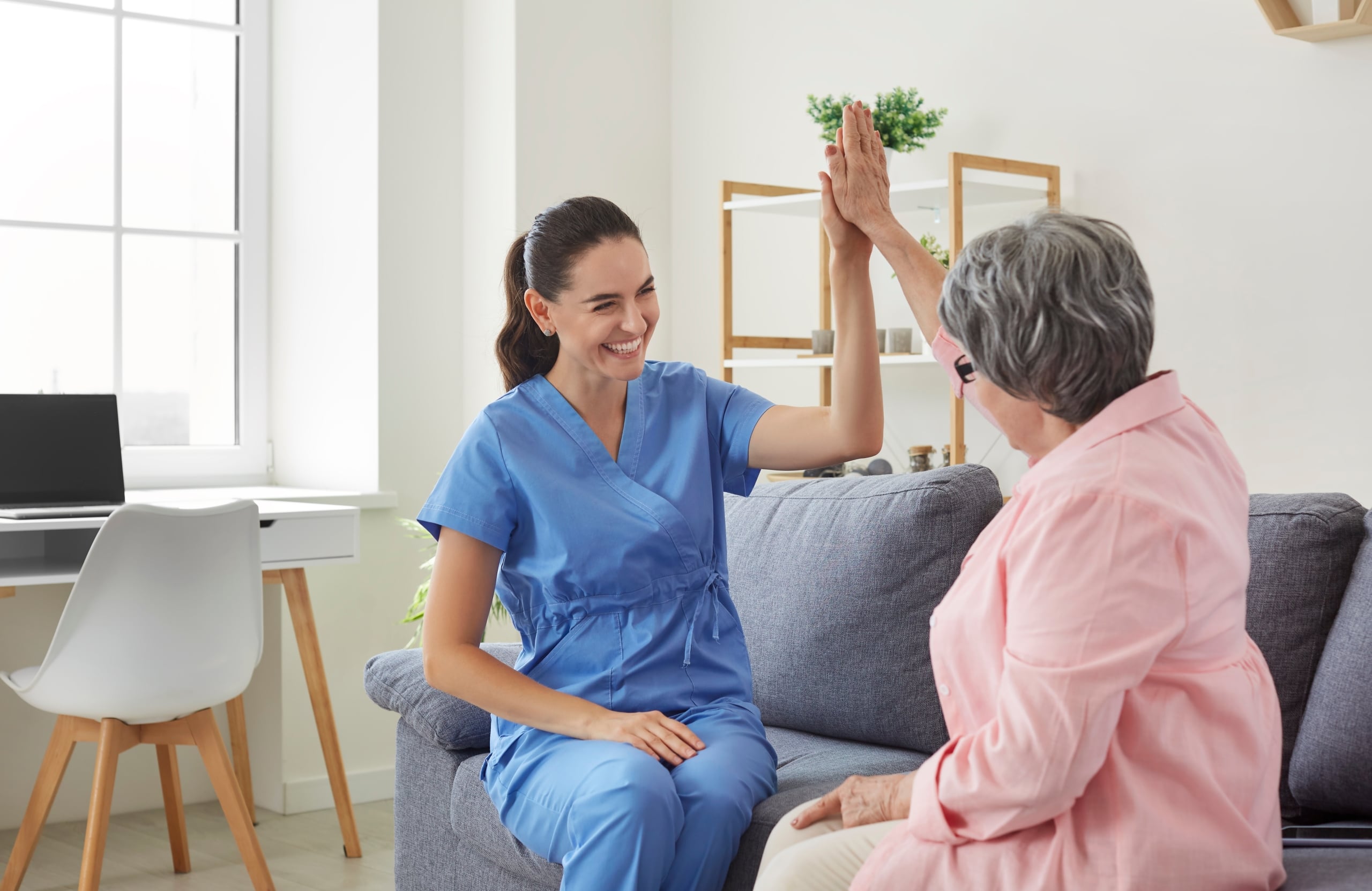 Cheerful medical professional giving a high five to a senior patient