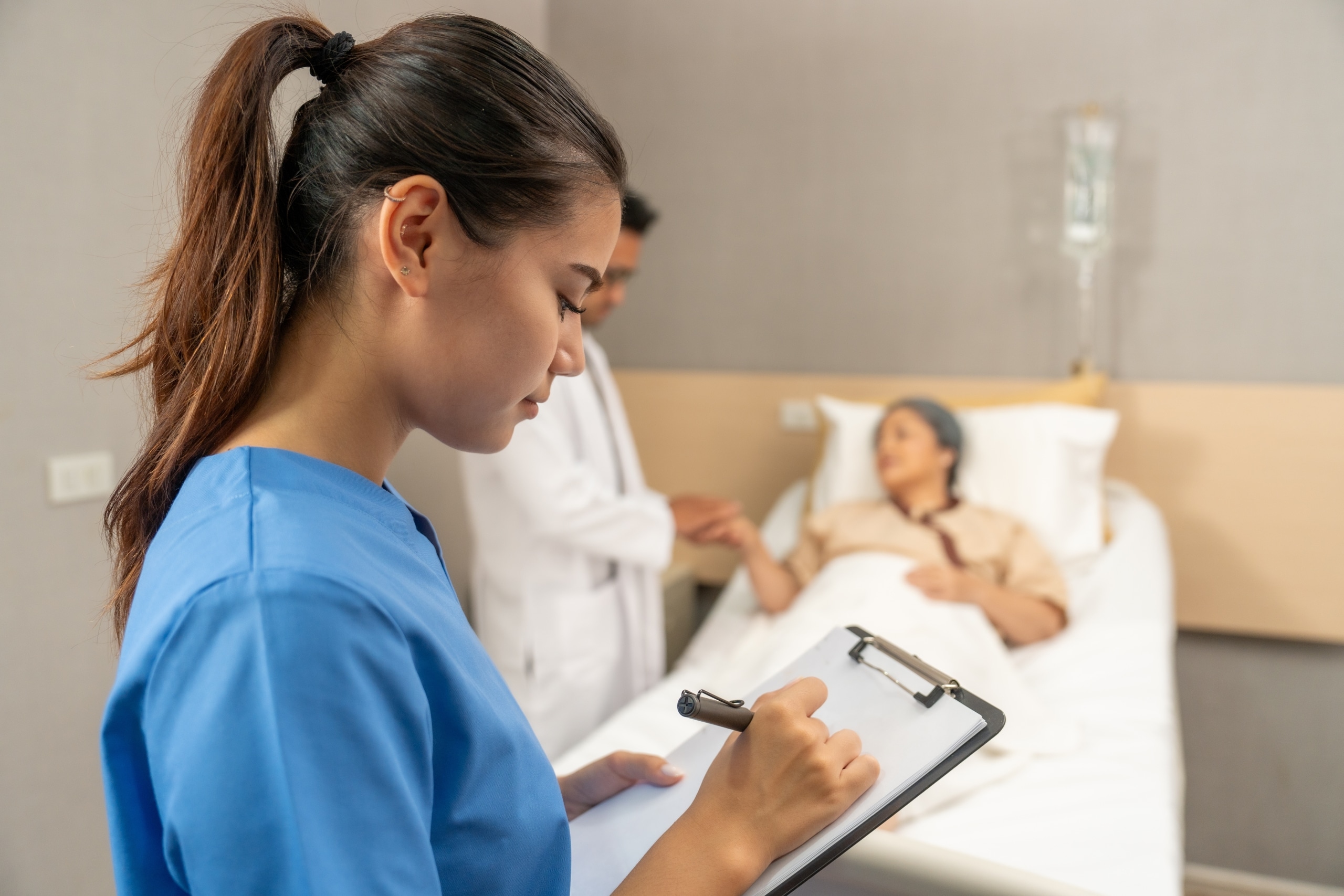 Asian nurse adding notes to a patient's chart