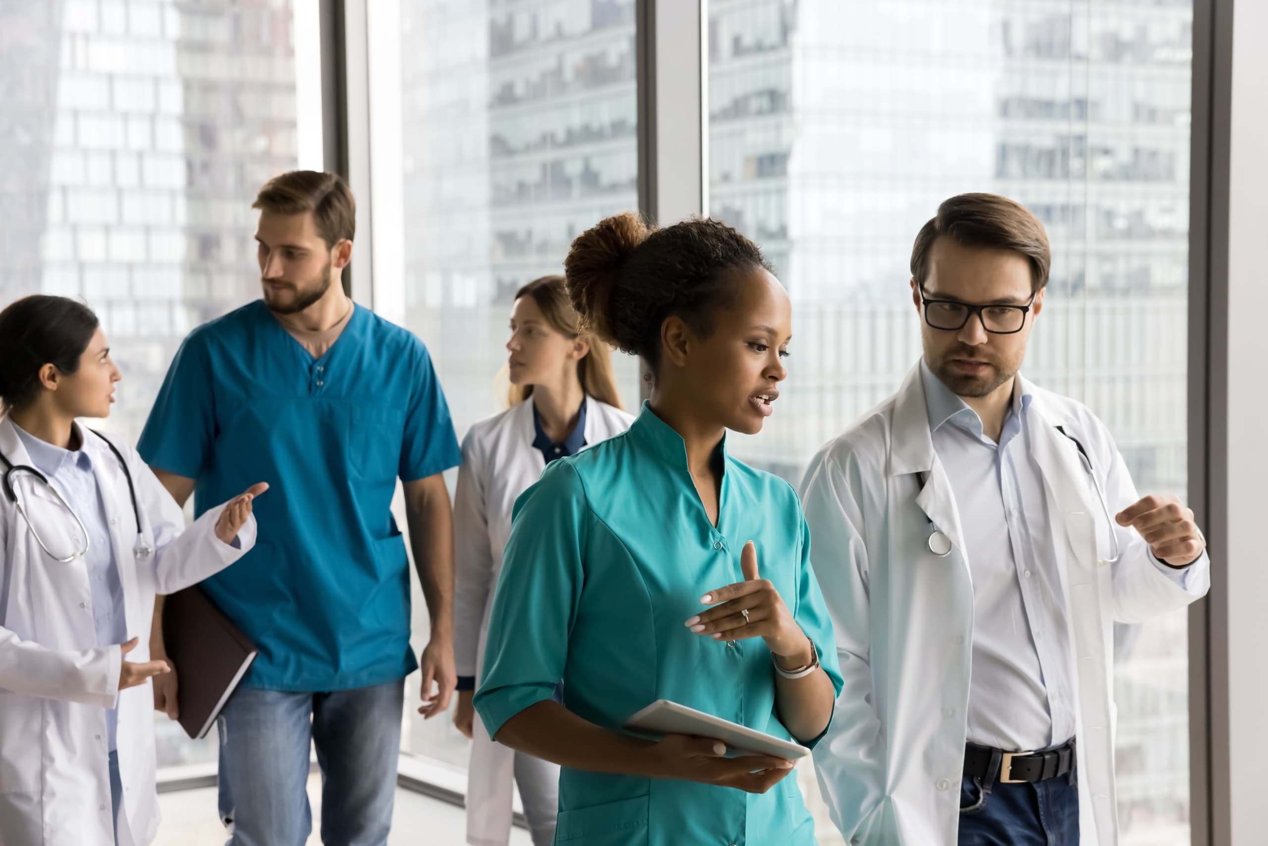 Diverse team of medical professionals walking in a hallway