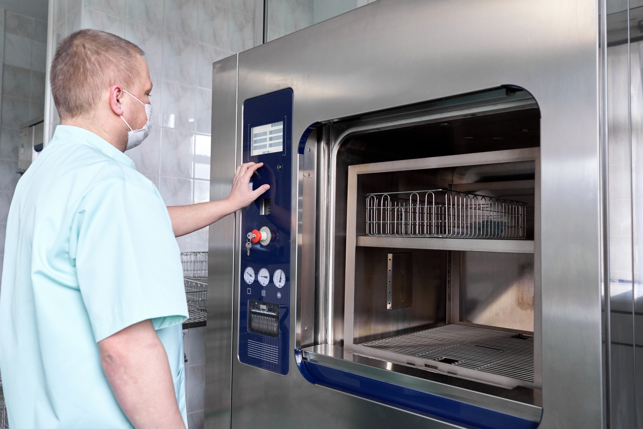 Man sterilizing medical equipment in a hospital