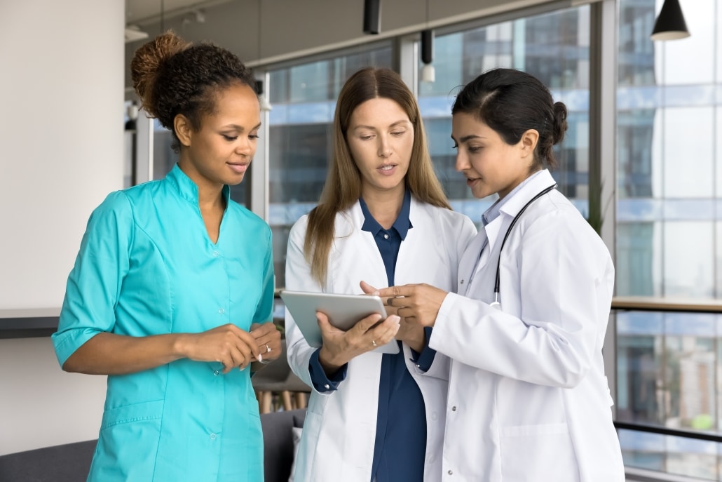 Diverse team of female medical professionals discussing a patient