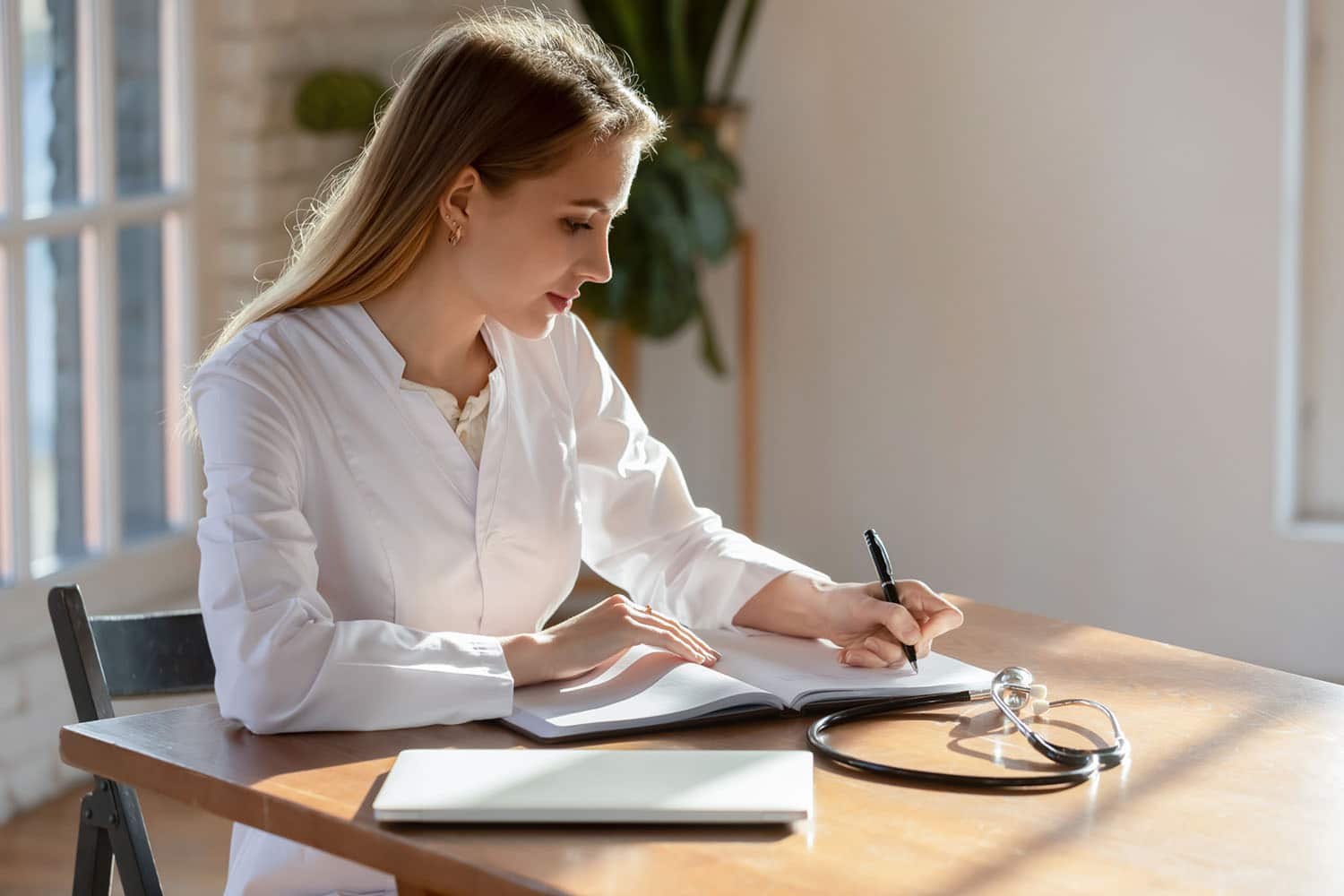 Nursing professional taking notes at a desk